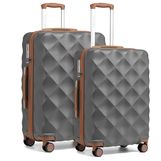 Duo de valises rigides grises au motif diamant avec finitions et poignées couleur cognac. Les deux valises sont équipées de poignées télescopiques en aluminium, de roulettes pivotantes et d’une fermeture sécurisée, combinant élégance moderne et praticité haut de gamme.
